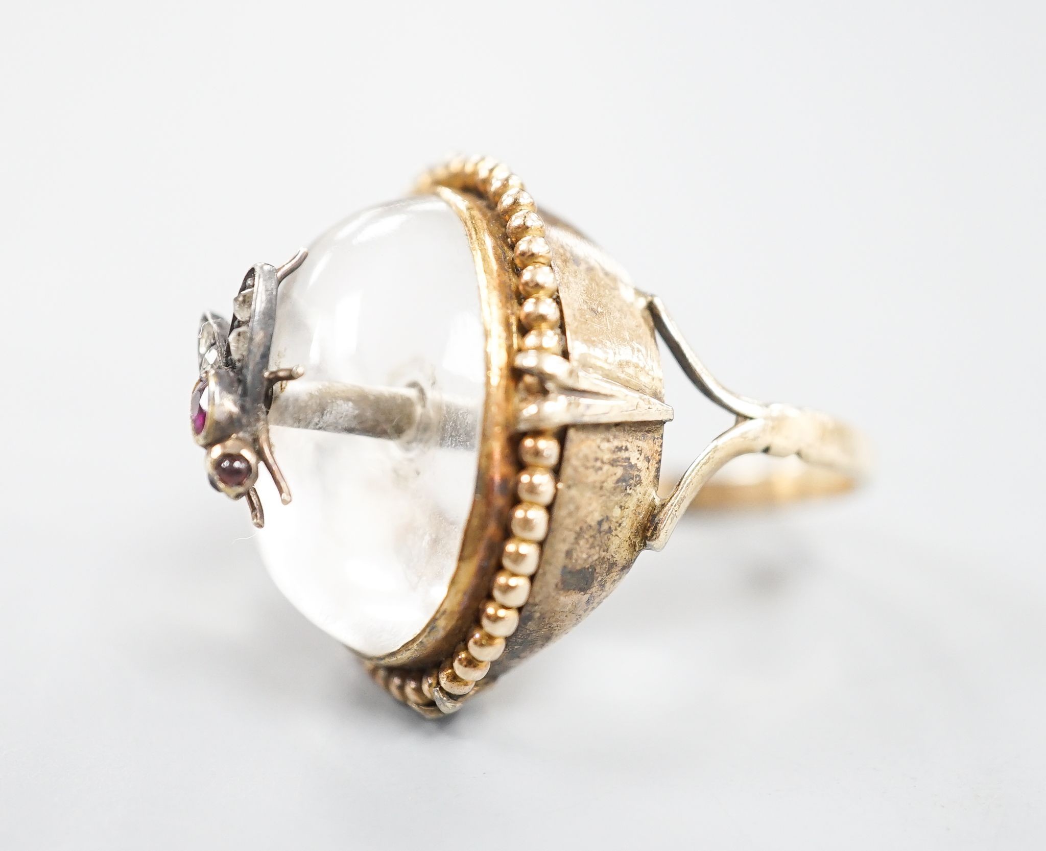 A Victorian, yellow metal and cabochon rock crystal? set dress ring, with central gem set bug motif, size R/S, gross weight 12.4 grams.